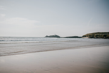 A beach with a lighthouse in the distance