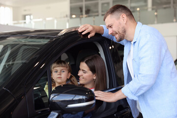 Happy family and new car in salon
