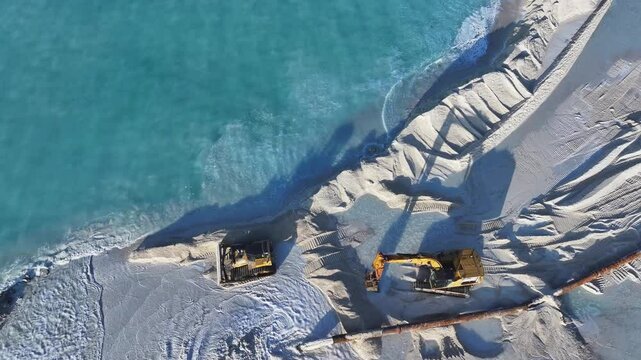 Aerial view of construction vehicles by the sea, Maldives.