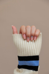 Elegant hand with stylish manicure and cozy sweater