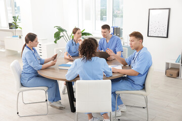 Obraz premium Medical students in uniforms studying together at table indoors