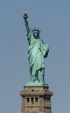 state isolated against a pale blue sky (iconic icon of freedom prosperity immigration arrivals) lady with torch and crown new york city harbor usa america of french gift new jersey