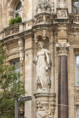 Fototapeta premium The statue on the historic buildings on the street Leysstraat in Antwerp