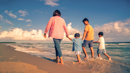 Asian family vacation holiday on the beach in the sunset