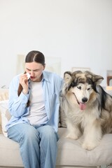 Woman suffering from allergy with her dog at home