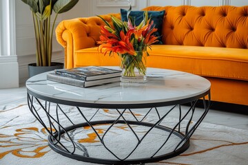 Round coffee table with black metal frame and white marble top, large glass surface for books or flowers, placed near yellow sofa on white carpet in warm inviting living room.