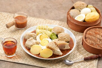 Siomay Bandung. Fish cake dumplings with potato, egg, and cabbage roll served with peanut, chili, sweet soy sauces and lime