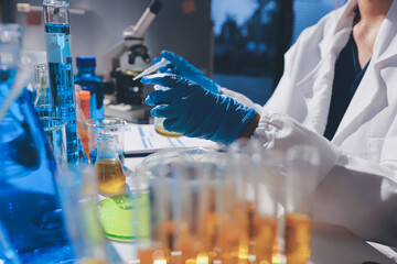 Scientist pipetting medical samples into microplate in laboratory