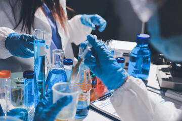 Scientist pipetting medical samples into microplate in laboratory