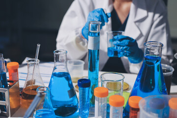 Scientist pipetting medical samples into microplate in laboratory