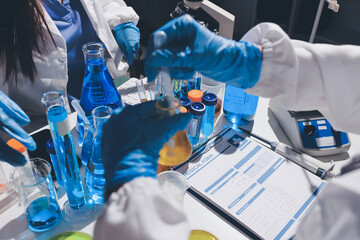 Scientist pipetting medical samples into microplate in laboratory