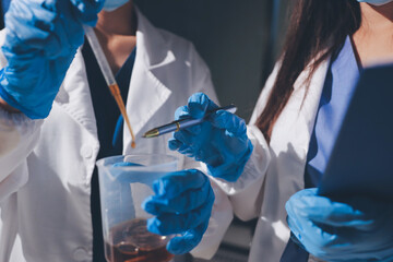 Scientist pipetting medical samples into microplate in laboratory