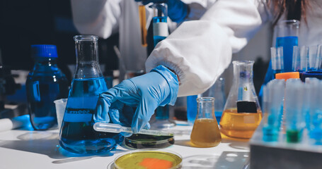 Scientist pipetting medical samples into microplate in laboratory
