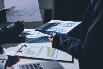 Group of business women working on a financial data expenses document.