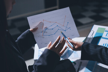 Group of business women working on a financial data expenses document.