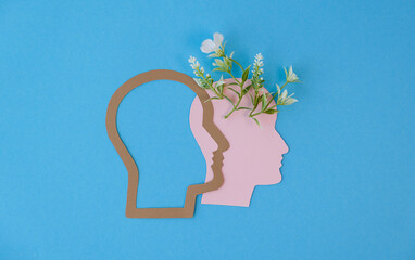 A head with a flower on it. The head is cut out of paper