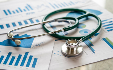 Medical stethoscope resting on financial charts illustrating healthcare data analysis and industry statistics in a business context.