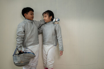 Before the tournament day, a boy and girl dressed in fencing gear are rehearsing in gym