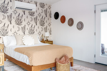 Southwest desert cowboy themed bedroom. Felt hats on the wall with a bed and pillows.