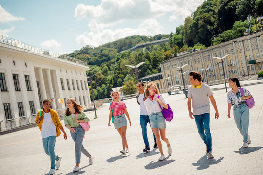 Group of young friends enjoying an outdoor walk through a sunny cityscape during a casual summer day - Powered by Adobe