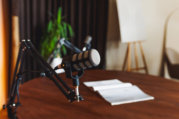 Podcaster preparing for an insightful discussion at a well-equipped recording studio with a premium microphone and notes nearby