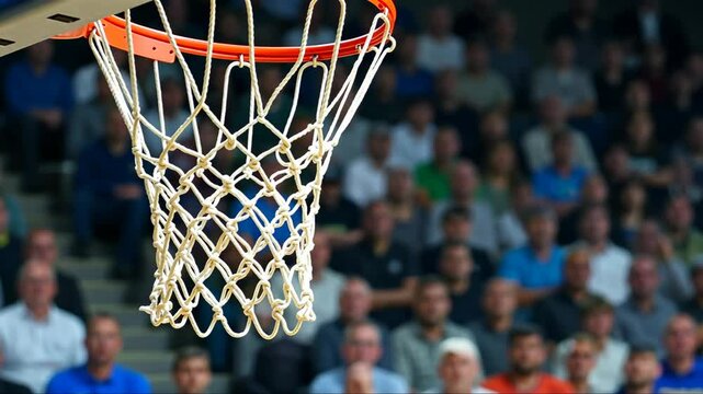 Close-up of a basketball hoop and net with a blurred crowd in the background. Concept of basketball game, sports, and competition. - Powered by Adobe