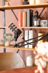 Podcast setup with a high-quality microphone on a wooden table in a cozy recording studio