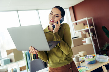 Busy professional businesswoman Starting a small business, multitasking on a phone call while...