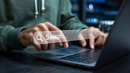 Person uses a laptop and types with a search bar overlay, finding information online for research or personal use, on a digital platform.