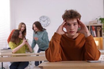 Teenage boy suffering from bullying at school, selective focus