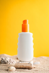 Sunblock or sunscreen in cosmetic tube on beach sand and beige background. Summer vacation and skin care concept with starfish and sea shells, spf uv-protect cosmetics. Skin health. High quality photo