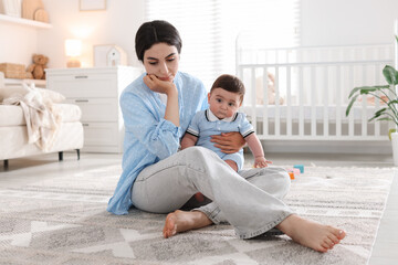 Woman suffering from postpartum depression with her little baby at home
