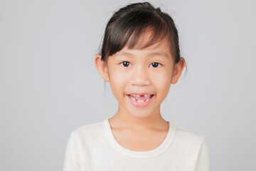 Happy kid girl smiles with missing tooth, dentist discusses tooth loss process. Asian child with gap learns about dental care and how new teeth grow naturally. isolated white background