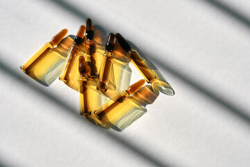 Ampoules with a medical drug on a gray background with stripes of shadows.