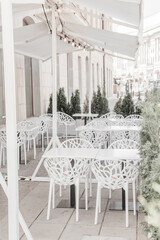 Empty Tables and Chairs at Outdoor Cafe street. Bar restaurant White umbrella patio background