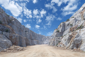 Open quarry with layered rock formations under blue sky