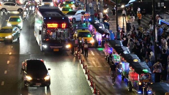Tuk Tuk taxis, metered taxis and buses at bus stop in Bangkok