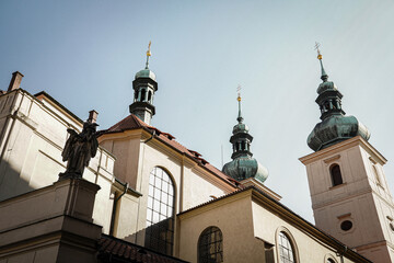 Baroque church towers and religious statue in Prague, Czech Republic