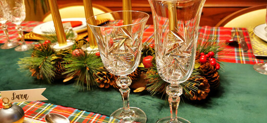 Table covered with a red and green checkered tablecloth for a Christmas atmosphere, with glassware and tableware, which adds a vibrant and cheerful touch to the space