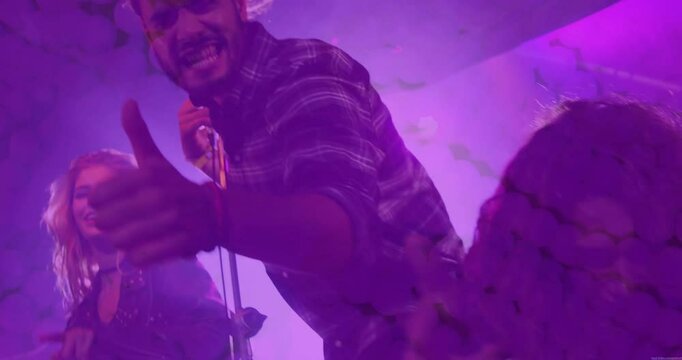 Lead singer gripping mic and singing first lines to energize concert crowd with animated soundwaves