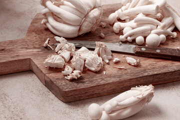 Freshly sliced Shimizhi mushrooms, on a wooden chopping board, ready to cook, close-up, no people,