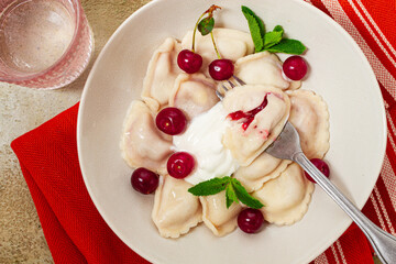 Traditional dumplings with cherries and yogurt, close-up, no people,