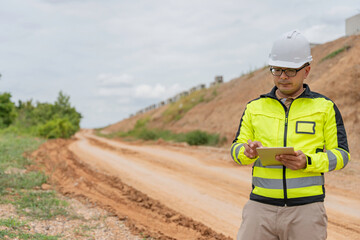 An Asian male engineer works at a motorway bridge construction site,Civil worker inspecting work on...