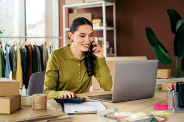 Young female entrepreneur managing her online fashion business from a stylish home office workspace