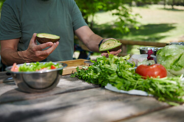 Preparing a Fresh Salad With Avocado Outdoors on a Sunny Day