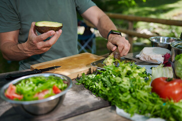 Outdoor Meal Preparation with Fresh Ingredients Including Avocado and Vegetables
