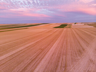 Aerial view of mowed wheat fields with pink clouds in the Champagne region