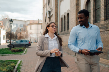 Business colleagues walking and talking on city street