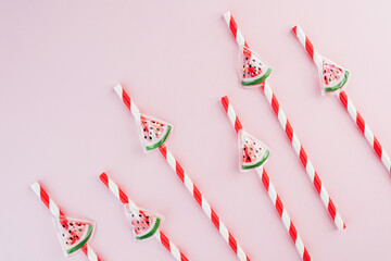  Closeup striped watermelon straws on pastel pink background for summer food concept