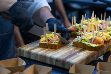 Chef prepares appetizers with precision in a bustling kitchen setting